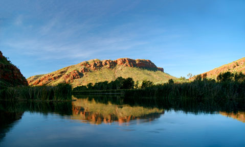 The Kimberley yacht charter region is tranquil with reflective water and orange rocks